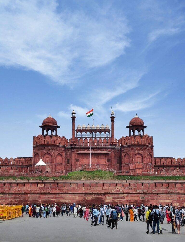 The historic Red Fort in Delhi under a blue sky with the Indian flag flying high.